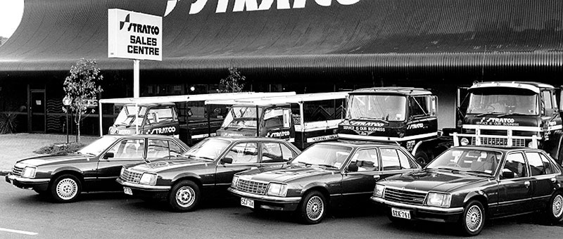 Stratco Sales Centre with vintage delivery trucks and cars parked in front